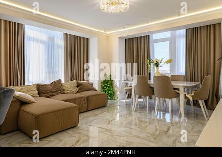 A classic kitchen and living room with a spacious and bright design in creamy colo Stock Photo