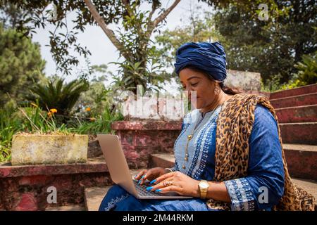 African woman works using her laptop, 50 year old lady and technology Stock Photo