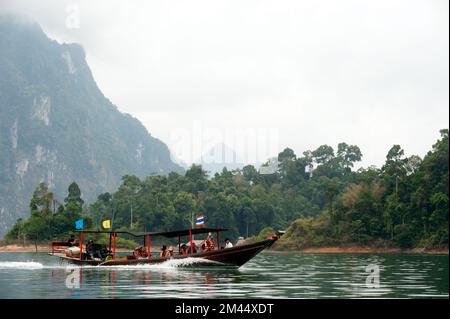 Traditional tourists boat in Cheow Larn lake in Khao Sok National park of Ratchaprapa Dam in Surat Thani Province ,Southern of Thailand. Stock Photo