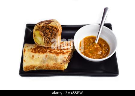 Mexican burrito with pork, cheese, potato served with sauce borracha Stock Photo