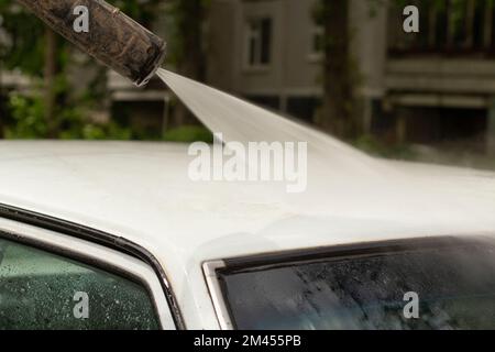 Wash car. Dirt laundering from machine. Water jet through transport. Work of car washer. Stock Photo