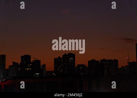 sunset with contrasting buildings and lights on, orange sky in guadalajara Stock Photo