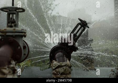 Valve on tube. Torn pipe valve. Boiling water pours from pipeline. Sewer breakout. Stock Photo