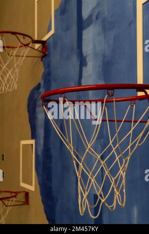 red basketball hoop with white woven net, detail background painting in blue Stock Photo