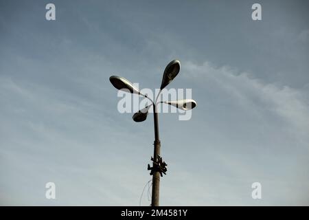 Four lamps on pole. Lighting fixture of old type. Old light pole. Stock Photo