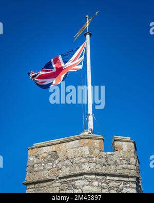 United Kingdom Union Jack flag blowing in the wind on top of Westgate Towers, Canterbury, England.  Stock Photo