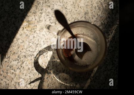 Cup of coffee on table. Morning drink. Transparent glass in kitchen. Quick breakfast without meals. Stock Photo