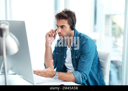We cant keep going over the same issue. a young call centre agent looking upset while working in his office. Stock Photo
