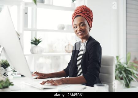 I really enjoy what I do. Cropped portrait of an attractive young businesswoman working at her desk in the office. Stock Photo
