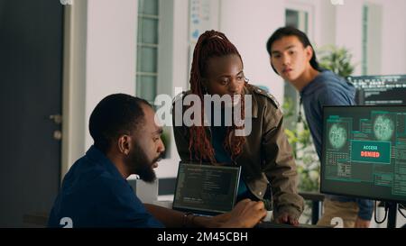 African american engineers programming code encountering system error on computer, dealing with hacked server and security breach alert. Coder having no access creating algorithm. Stock Photo
