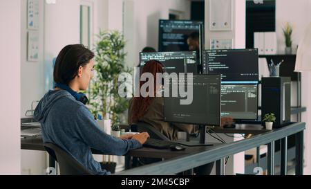 Asian software programer writing code on computer, displaying artificial intelligence algorithm. App developer coding database program, doing cloud computing with it server. Tripod shot. Stock Photo