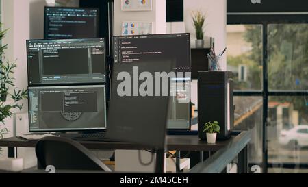 Computer screens on desk running programming code data algorithms in empty coding room. Database network servers cloud computing in software it agency office, html script language. Stock Photo