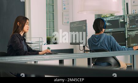 Database programer writing source code with coding language in it development room. App developer working on database programming with html script, computing big data. Handheld shot. Stock Photo