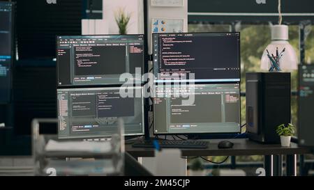 Empty office desk with multiple screens running software developing script on terminal window, it agency computers showing code database algorithms, network servers innovation. Stock Photo