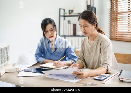 Engineering construction concept, Two female engineers is discussing construction and taking notes. Stock Photo