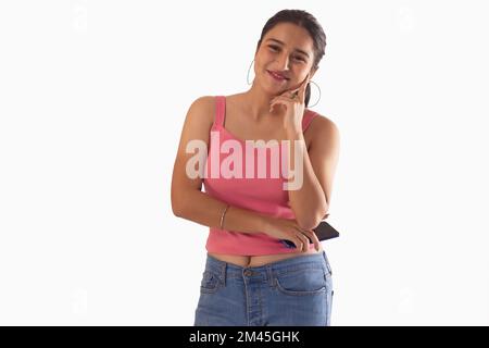 Portrait of smiling teenage girl standing against white background Stock Photo