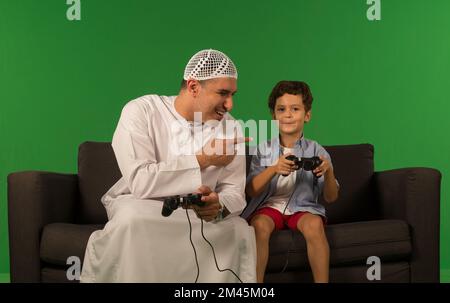 Emirati father with son playing video game. Stock Photo