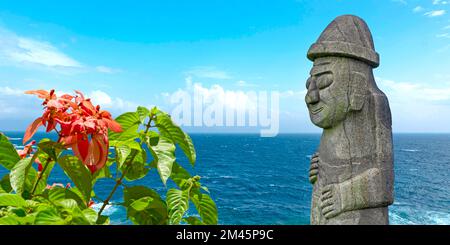 Stone Dol Hareubang in Jeju Island and panorama of sea in South Korea Stock Photo