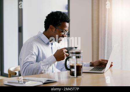 Making my home a productive area. a handsome young businessman working on his laptop at home. Stock Photo