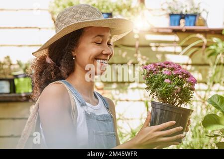 Woman, smile and flower pot plant while shopping at florist shop for buying gardening plants at a nursery and garden store. Black female or happy Stock Photo
