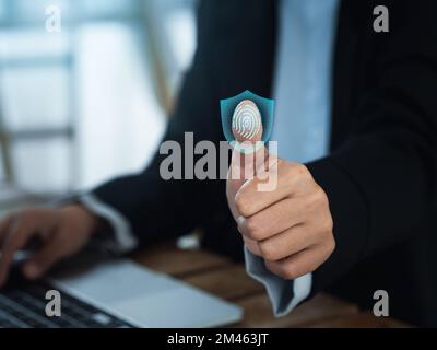 Fingerprint scan with digital safety shield icon on virtual screen while thumb scanning for security access, login with biometrics identification. Cyb Stock Photo