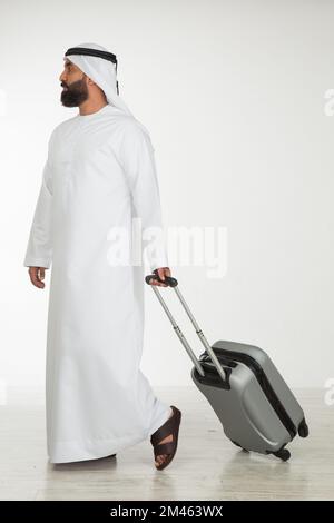 Emirati man carrying a suitcase. Stock Photo