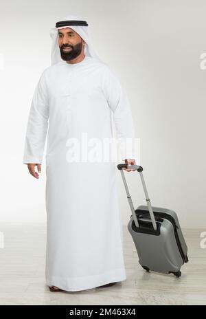 Emirati man carrying a suitcase. Stock Photo