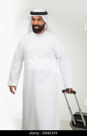 Emirati man carrying a suitcase. Stock Photo