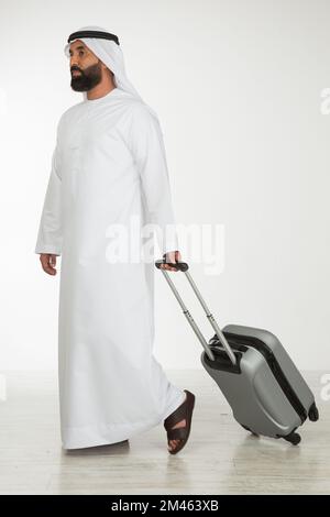 Emirati man carrying a suitcase. Stock Photo