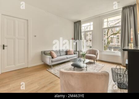 The interior of a spacious living room in an open design with a big sofa and carpet in a cozy house Stock Photo