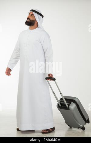 Emirati man carrying a suitcase. Stock Photo