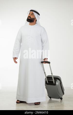 Emirati man carrying a suitcase. Stock Photo