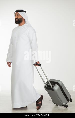 Emirati man carrying a suitcase. Stock Photo