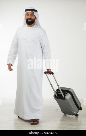 Emirati man carrying a suitcase. Stock Photo