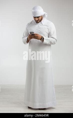 Emirati man texting on his mobile. Stock Photo