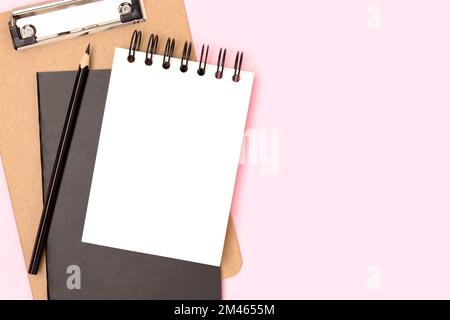Workspace with blank notepad mockup, eyeglasses and stationery on a pink background. Back to school concept. Stock Photo