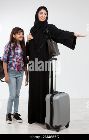 Arab mother and her daughter travelling. Stock Photo