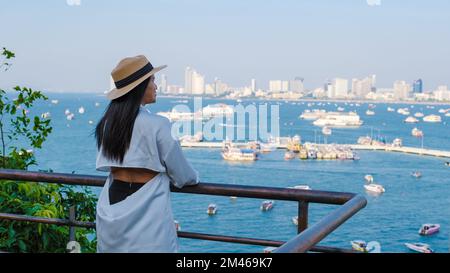 Asian Thai women at a view point looking out over the city of Pattaya skyline from the hill viewpoint Pattaya Thailand.  Stock Photo