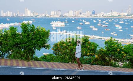 Asian Thai women at a view point looking out over the city of Pattaya skyline from the hill viewpoint Pattaya Thailand.  Stock Photo