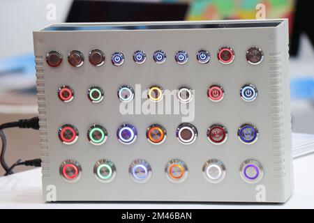 Electrical switches or modern push buttons with lights to control various electronic devices are installed on a panel Stock Photo