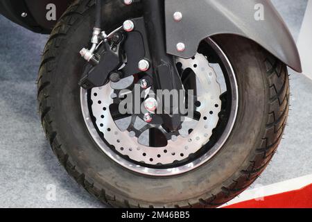 Electric scooter disc brakes with modern design installed on the front wheel with a view of aluminum alloy rim and shock absorbers Stock Photo