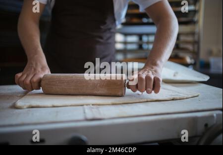 Close-up of young baker preparing pastries in bakery. Stock Photo