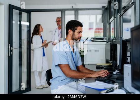 Young doctor working on computer in his office. Stock Photo