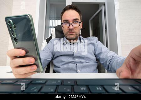 Businessman typing on laptop computer keyboard and using mobile smartphone. Businessman connecting internet, networking in modern office, closeup. wi- Stock Photo