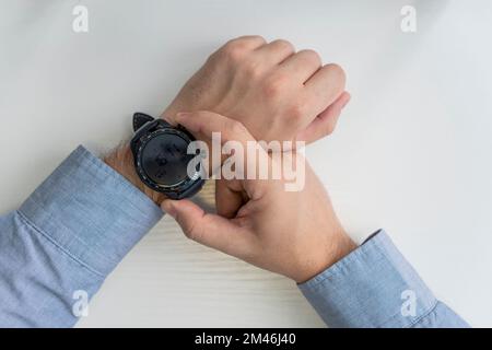 business, technology and people concept. close up of male hands setting smart watch. top view Stock Photo