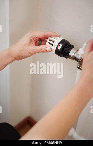 Woman using radiator thermostat Stock Photo