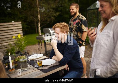 Happy friends having meal in garden Stock Photo