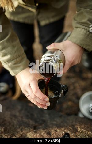 Hands pouring coffee from thermos Stock Photo