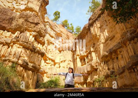 Female geologist with backpack exploring nature trail in forest and analyzing rock or gravel. Researchers collect samples of biological materials. Env Stock Photo