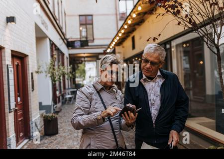 Senior couple using smart phone in city Stock Photo